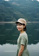 Serene Young Woman in Green Dress by Mountain Lake
