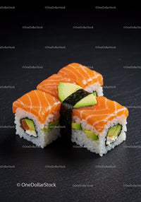 Fresh salmon sushi rolls with avocado on black plate