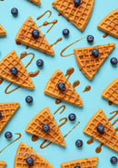 Blueberry topped waffles with caramel drizzle on blue