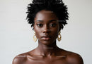 Elegant Black Woman with Natural Curly Hair and Pearl Earrings