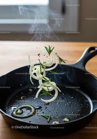 Sizzling onion rings with rosemary in cast iron skillet
