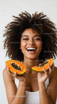 Joyful Woman with Curly Hair Holding Fresh Papaya Slices for Summer Vibes