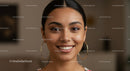 Portrait of Smiling Young Woman with Hoop Earrings in Indoor Setting