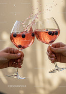 Two people clinking glasses of sparkling berry drink