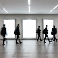 Blurred Businesspeople Walking by Bright Urban Advertisements