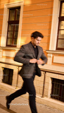 Stylish man buttoning blazer on urban street at night