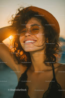 Portrait of a Smiling Woman Wearing Sunglasses and a Sun Hat Outdoors