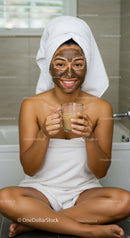 Happy Woman Enjoying Facial Mask and Tea in Home Spa Setting