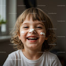 Happy child with cream on face laughing indoors
