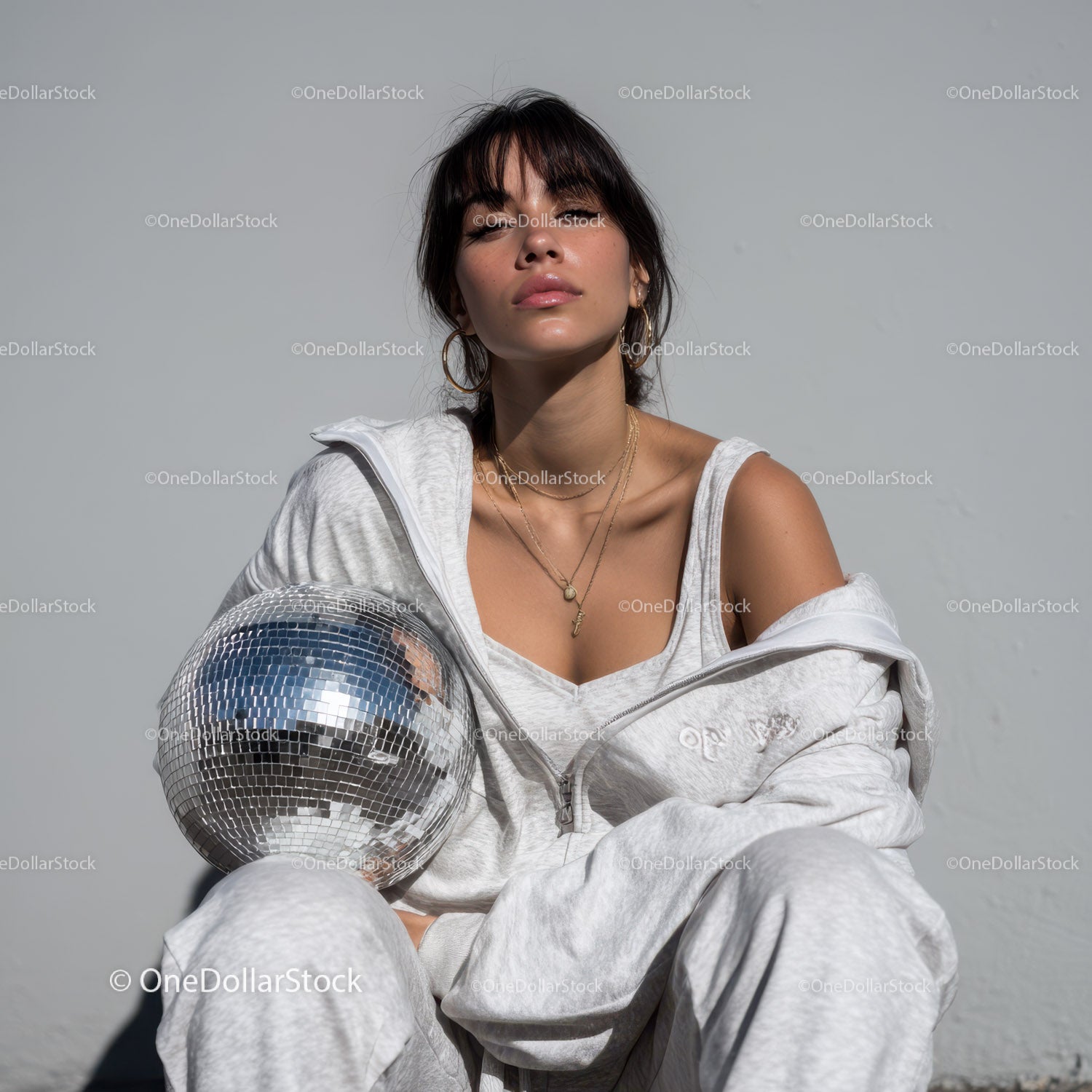 Stylish Woman in Metallic Outfit Holding Disco Ball for Modern Fashion