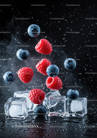 Fresh blueberries and raspberries with ice cubes splash