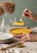 Elegant Lemon Tart with Slice being Lifted on a Stylish Table