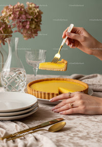 Elegant Lemon Tart with Slice being Lifted on a Stylish Table