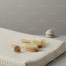 Minimalist baby grooming brush and pacifiers on changing pad