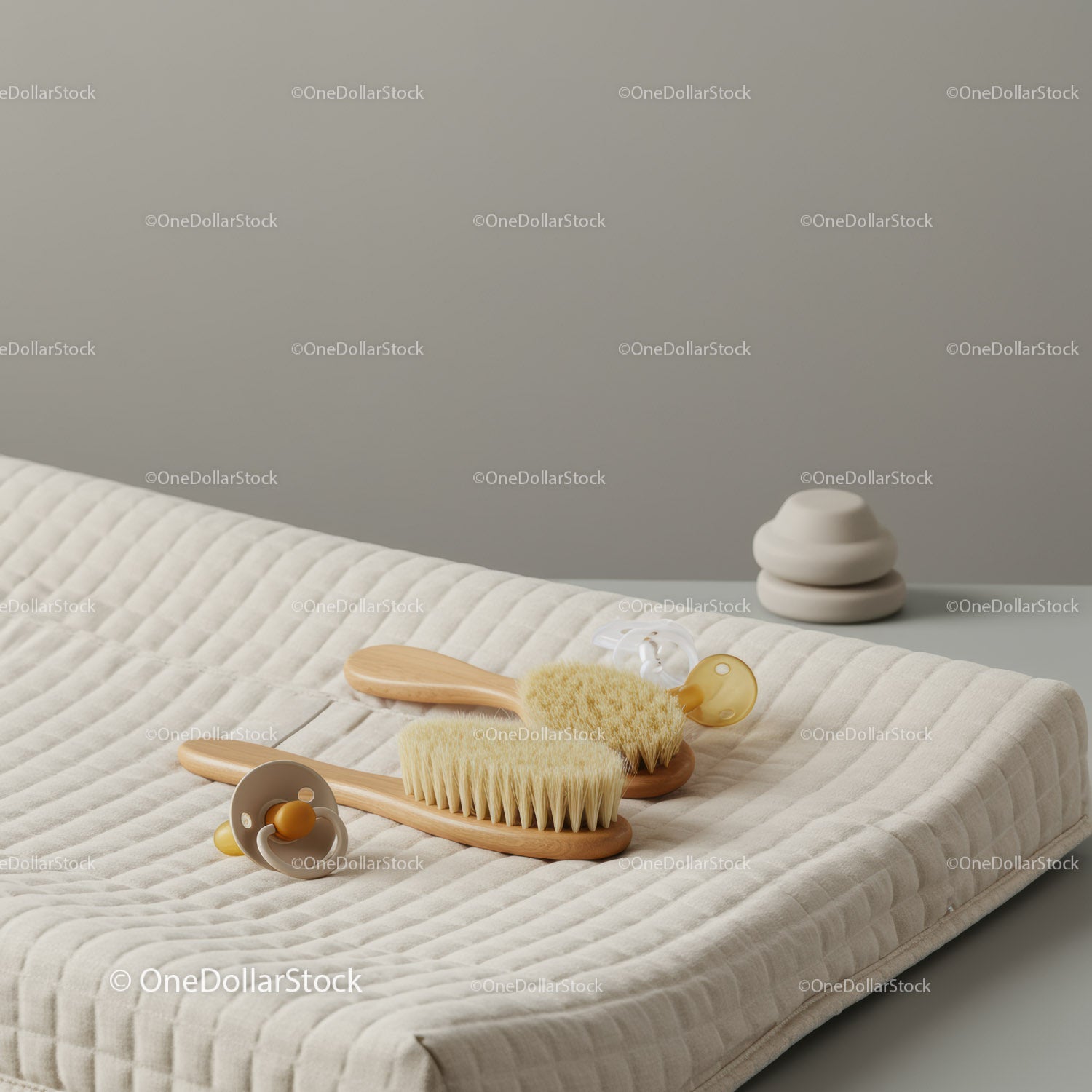 Minimalist baby grooming brush and pacifiers on changing pad