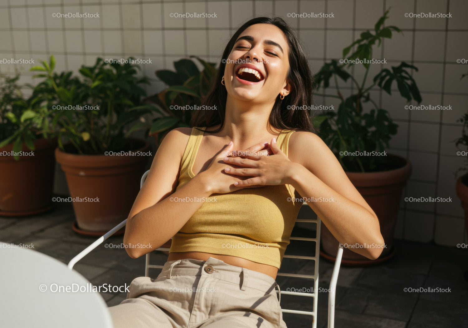 Joyful Woman Laughing Outdoors in Sunlit Garden with Greenery