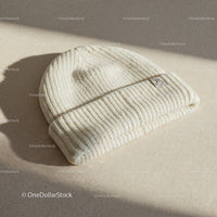 Cozy cream knit beanie hat on textured fabric surface