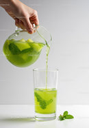 Refreshing mint and cucumber water being poured in glass