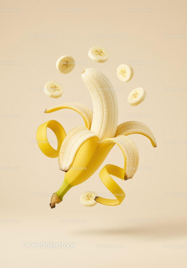 Peeled banana with floating slices on beige background