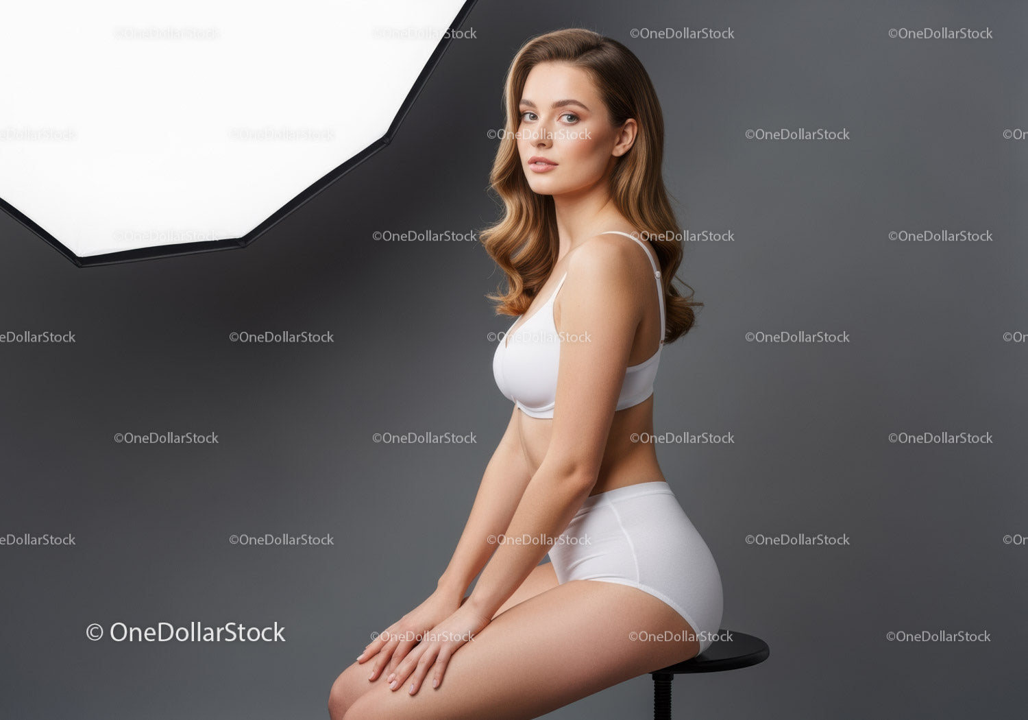 Elegant Young Woman in White Lingerie Sitting on Stool Against Grey Background