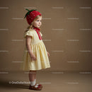Little girl wearing strawberry hat and yellow dress