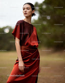 Elegant woman posing in silk rust red dress outdoors