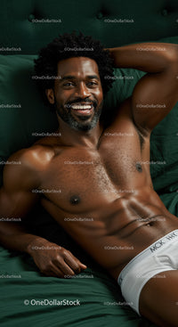 Smiling man relaxing on green bed in white underwear