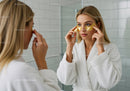 Young Woman Applying Gold Eye Patches for Skincare Ritual