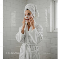 Relaxing Woman Applying Facial Mask in Bathroom