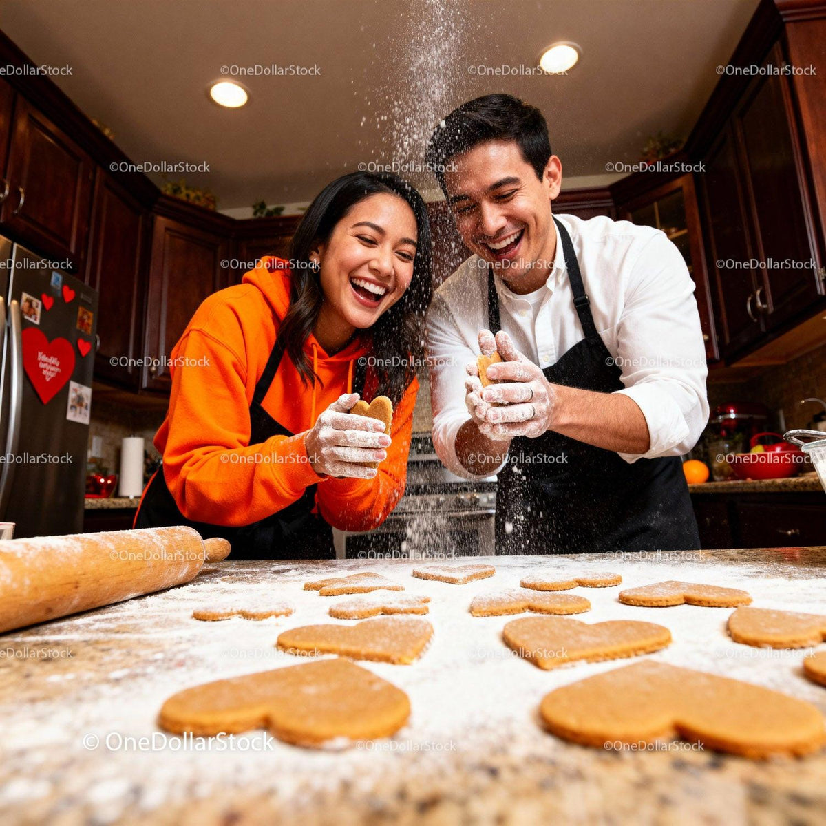 Couple laughing while baking heart shaped cookies