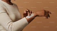 Woman Applying Body Lotion with Skincare in a Minimalist Studio
