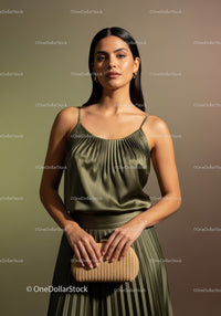 Elegant Woman in Beige Satin Top and Pleated Skirt with Woven Clutch