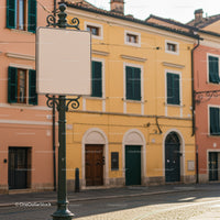 Empty vintage street sign amidst pastel town buildings
