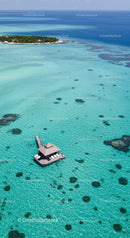 Overwater Bungalow in Bright Turquoise Lagoon Surrounded by Coral Reefs