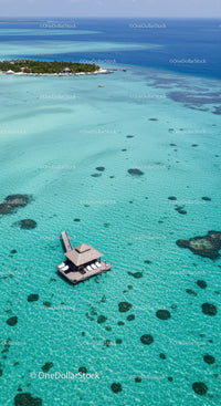 Overwater Bungalow in Bright Turquoise Lagoon Surrounded by Coral Reefs