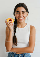 Smiling Young Woman Holding Peach in Casual Outfit