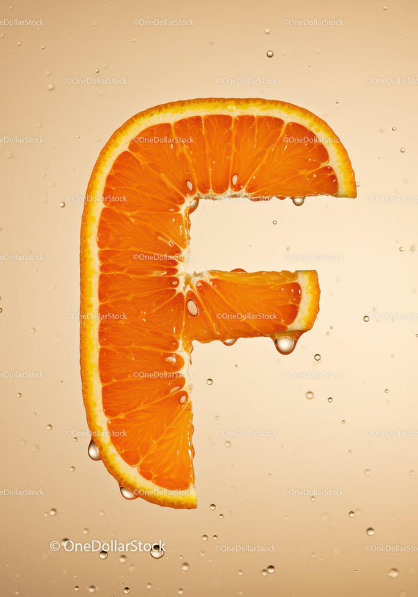 Fresh orange slice shaped like letter F with water droplets