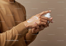 Close-up of Hands Applying Skin Lotion in Neutral Background