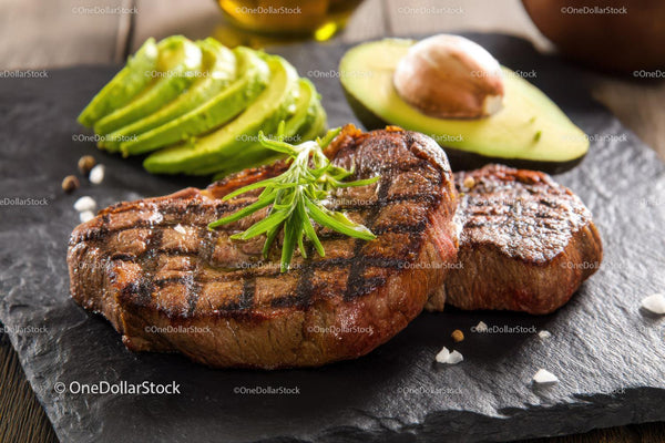 Juicy Grilled Steak with Avocado and Basil on Black Slate