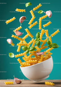 Flying fusilli pasta with garlic and fresh basil leaves