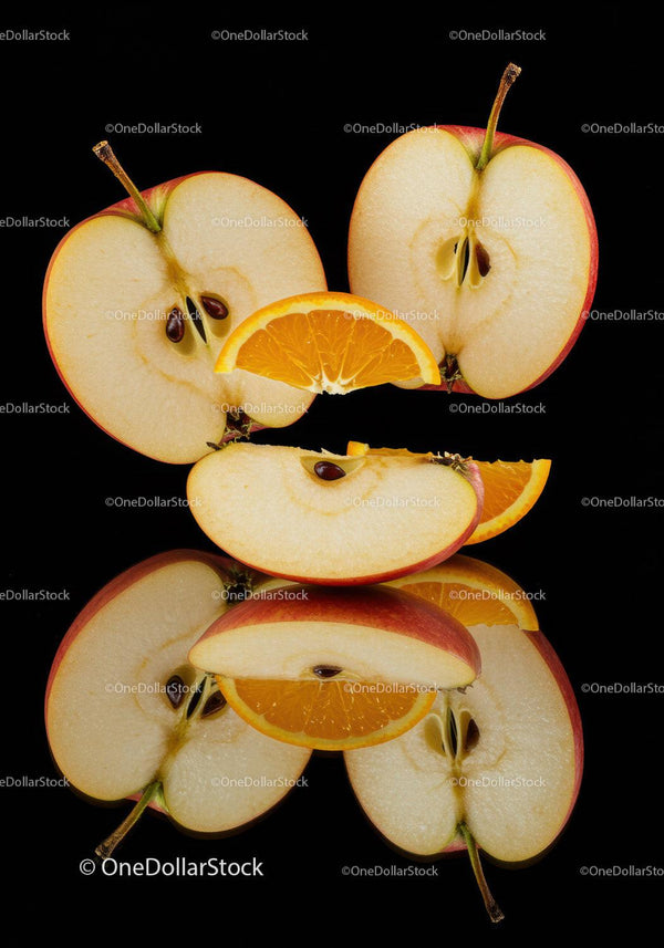 Fresh apple slices with juicy orange wedges on black