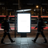 Illuminated bus stop advertising panel at night city street