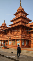 Red Sandstone Temple with Tiered Roof and Ornate Carvings