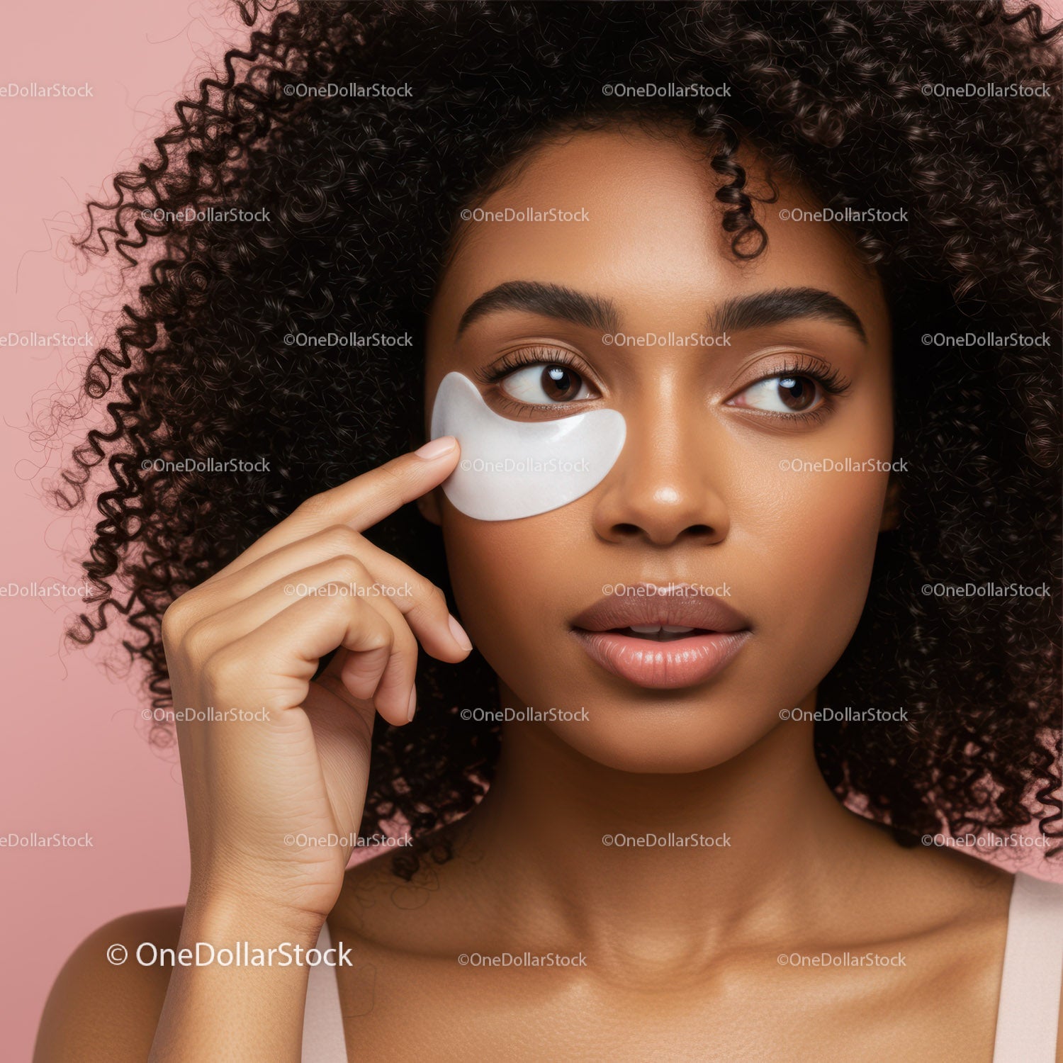 Woman with Curly Hair Applying Eye Patch for Skincare Routine