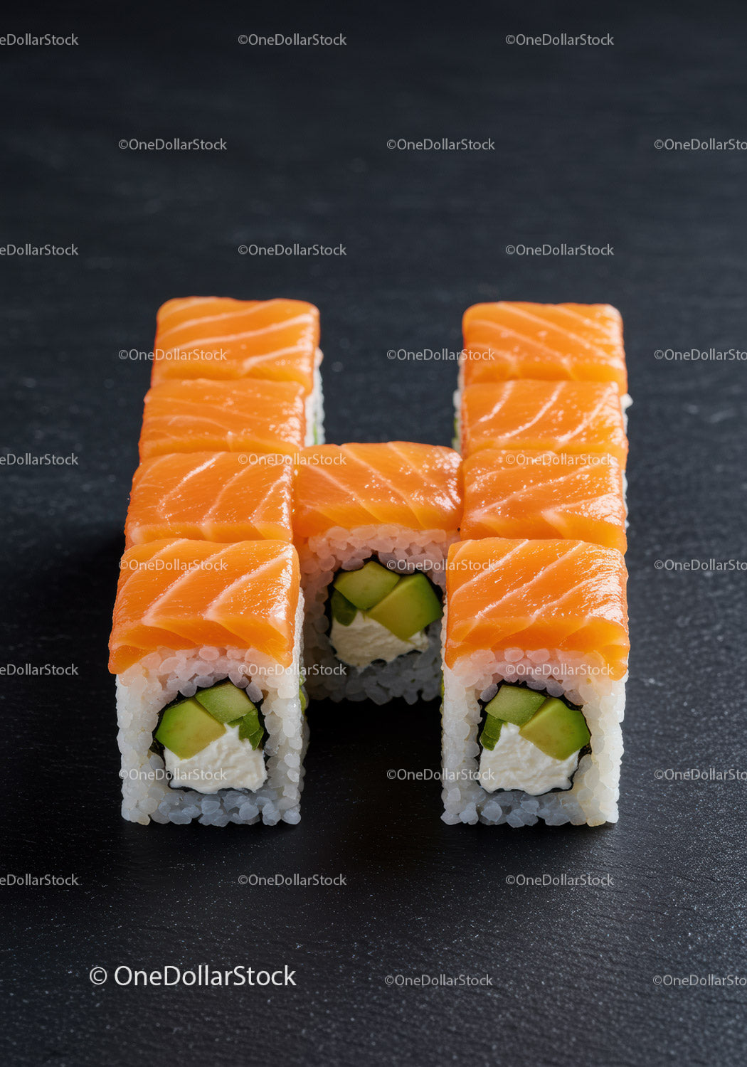 Fresh salmon sushi rolls arranged on black surface