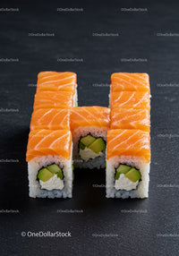 Fresh salmon sushi rolls arranged on black surface