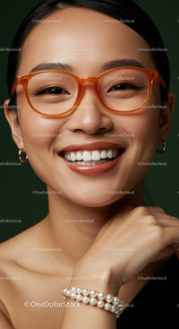 Smiling young woman with stylish orange glasses and pearls