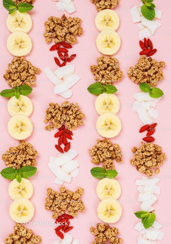 Healthy breakfast ingredients laid out on soft pink background
