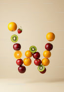 Letter W formed by suspended fresh fruits on beige