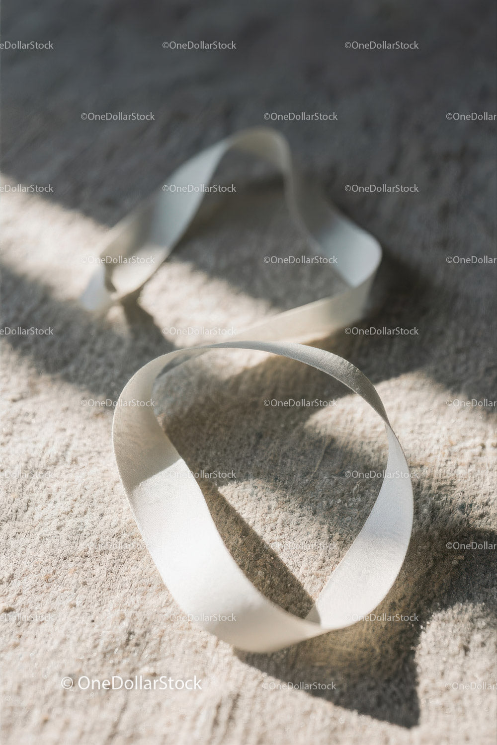 Close-up of White Plastic Ribbon Waste on Sandy Beach